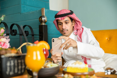 صورة مقربة لمائدة طعام خاصة برجل سعودي خليجي ، يقضي اجواء رائعة  في المطعم ، العديد من أصناف الطعام و الماكولات على الطاولة ، متجر و مطعم سعودي