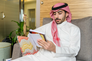 شاب سعودي خليجي مثقف يقضي وقته في المكتبة و يقرأ الكتب ، قراءه كتب ،  الدراسة في المكتبة