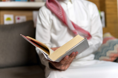 شاب سعودي خليجي مثقف يقضي وقته في المكتبة و يقرأ الكتب ، قراءه كتب ،  الدراسة في المكتبة