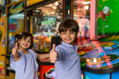طفلان سعوديان في مدينة الألعاب ، يلعبان العديد من الألعاب الالكترونية المتنوعة و المسلية  ، قضاء اوقات رائعة في مدينة الملاهي ، العاب الكترونية ، التسلية و الترفيه ، الترفيه في العطلة الصيفية