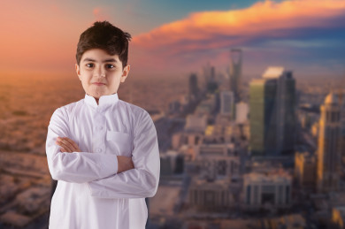 طفل عربي خليجي سعودي ، يرتدي ثوب سعودي تقليدي ، يقف مكتف يديه متأمل ويفكر ، خلفه مدينة الرياض   ، أبراج وناطحات سحاب ، معالم مدينة الرياض ، مدينة حديثة متطورة