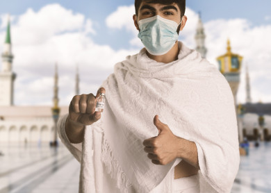 رجل مسلم عربي سعودي خليجي بلباس الاحرام ،  اتباع تعليمات و شروط الحج لعام 2021 ، اخذ جرعة اللقاح الآمنة ، التطعيم الأمن لكوفيد 19  ، فريضة الحج ، اداء مناسك الحج و العمرة ، مع خلفية للحرم المكي