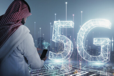 صورة مقربة من الخلف لرجل عربي خليجي سعودي بيده موبايل أمام اختصار الجيل الخامس للشبكات 5G و أبراج المملكة بتقنية الهولوجرام ، استخدام خاصية الهولوجرام ثلاثية الأبعاد .