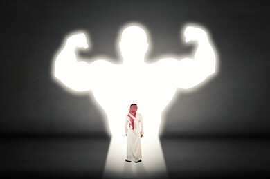 صورة من الخلف لرجل عربي خليجي سعودي يرتدي الزي التقليدي السعودي أمام خيال شخص يتمتع باللياقة البدنية و القوة ،  قوة و قدرة و نجاح ، تحقيق الطموحات و الاهداف المستقبلية