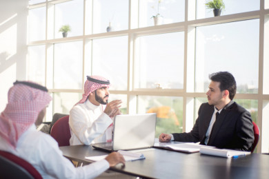 اجتماع رجال اعمال سعوديين مع رجل عربي ببدلة  ، توقيع عقود ، شركة سعودية ، شركاء العمل ، وظيفة مكتبية ، استخدام الكمبيوتر المحمول ، بيئة العمل