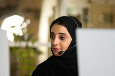 موظفة سعودية شابة في بيئة العمل , تعمل بالدعم الفني عبر الكمبيوتر