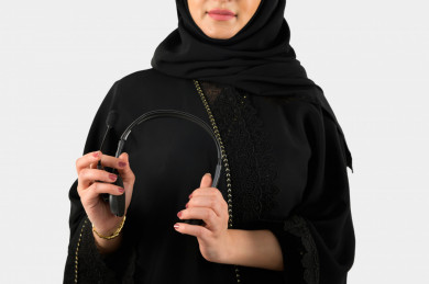 بورتريه مرأة سعودية خليجية, مع سماعات رأس صوتية , بخلفية بيضاء