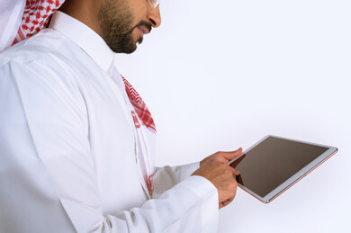 بورتريه رجل سعودي عربي خليجي , لبس سعودي تقليدي ، استخدام جهاز لوحي تابلت بخلفية بيضاء
