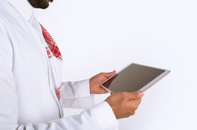 بورتريه رجل سعودي عربي خليجي , لبس سعودي تقليدي ، استخدام جهاز لوحي تابلت بخلفية بيضاء