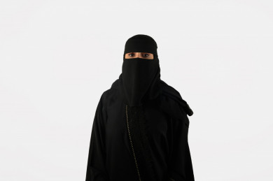 بورتريه مرأة سعودية عربية منقبة , بعباية سوداء بخلفية بيضاء
