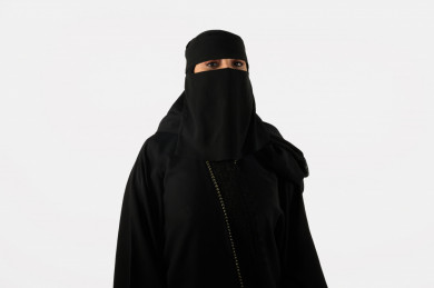 بورتريه مرأة سعودية عربية منقبة , بعباية سوداء بخلفية بيضاء
