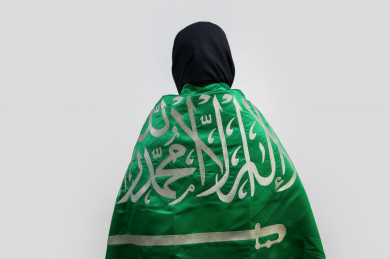 مواطنة سعودية تضع علم المملكة العربية السعودية  على ظهرها 