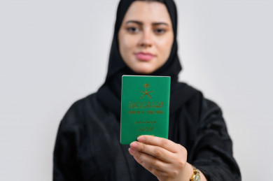 إمرأة سعودية تمسك جواز السفر السعودي , يوم الوطني 