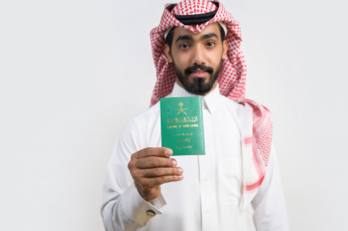 شاب سعودي يحمل جواز السفر السعودي , يوم الوطني 