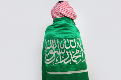 شاب سعودي يضع علم المملكة العربية  السعودية على ظهره 
