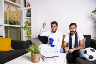 صديقان سعوديان يشاهدان مباراه للدوري السعودي ، احدهم يشجع فريق الشباب و الاخر يشجع فريق الهلال ، ايماءات وجه مختلفة