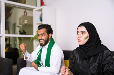 زوجان سعوديان يشاهدان مباراه للدوري السعودي ، كلاهما يشجعان فريق الاهلي و فريق السعودية