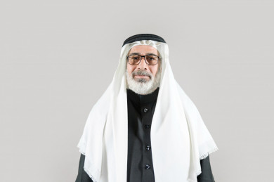 بورتريه رجل سعودي كبير بالسن يرتدي ثوب أسود مع غترة وعقال بخلفية بيضاء