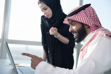 اجتماع رجل اعمال سعودي خليجي مع السكرتيرة في مكتب العمل ، العمل على الكمبيوتر المحمول ، فريق عمل ، سكرتيرة اعمال ، بيئة عمل