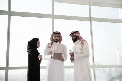 رجلان أعمال سعوديين خليجيان ينظمان للإجتماع مع السكرتيرة التي تقوم بتسجيل الملاحظات ،استخدام التابلت ف التنظيم ، شركاء عمل