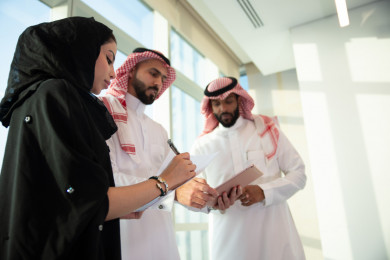 رجلان أعمال سعوديين خليجيان ينظمان للإجتماع مع السكرتيرة التي تقوم بتسجيل الملاحظات ،استخدام التابلت ف التنظيم ، شركاء عمل