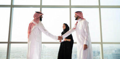 رجلان عربيان سعوديان يتصافحان بعد اجتماع عمل ناجح باللباس السعودي التقليدي  ، سكرتيرة أعمال في عباية سوداء , شركة سعودية ناجحة ، شركاء عمل ، بيئة عمل