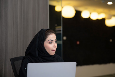 سيدة اعمال عربية سعودية تعمل في المكتب . تستخدم الكمبيوتر المحمول ، شركة سعودية ، بيئة عمل