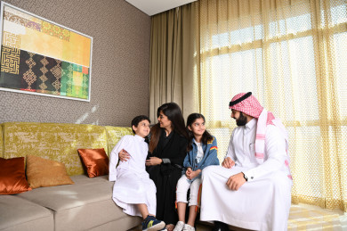 عائلة سعودية سعيدة  مجتمعة في غرفة المعيشة