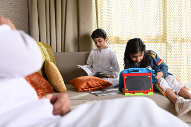 أطفال سعوديين يلعبون بألعاب تعليمية في غرفة المعيشة  