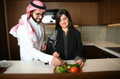 زوجان سعوديان يساعدان بعضهم في تحضير الطعام 