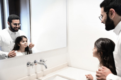 أب خليجي يساعد على تنظيف أسنان إبنته 
