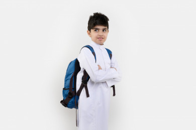 بورتريه لفتى طالب مدرسي سعودي مبتسم ، يرتدي حقيبة ظهر مدرسية ، و يرتدي ثوب سعودي تقليدي ،مدرسة سعودية