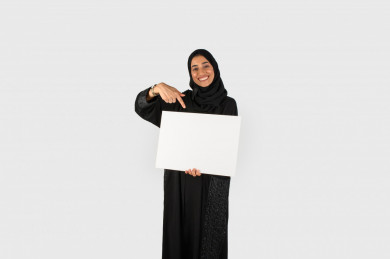 بورتريه بنت سعودية خلف لوحة بيضاء صغيرة فارغة ، لوحة فارغة ، بنت خليجية تحمل لوح ابيض ، بخلفية بيضاء