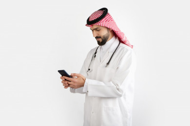 بورتريه رجل طبيب سعودي عربي مسلم ، استخدام الهاتف المحمول ، خلفية بيضاء