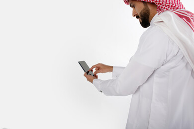 بورتريه رجل سعودي خليجي ، لبس سعودي تقليدي ، استخدام الهاتف المحمول ، خلفية بيضاء