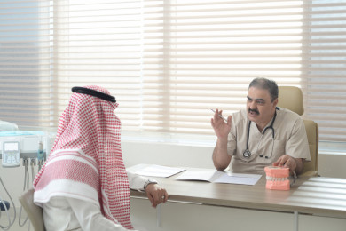 طبيب سعودي يتحدث مع مريض ويقدم له استشارات طبية 
