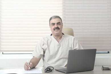 طبيب سعودي كبير بالسن يعمل بالمكتب في العيادة 