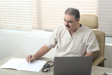 طبيب سعودي كبير بالسن يعمل بالمكتب في العيادة 