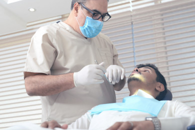 طبيب اسنان عربي يعالج مريض  سعودي في العيادة 
