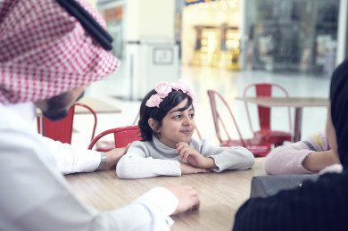 عائلة سعودية سعيدة تجلس في ردهة المطاعم في المول , عائلة سعودية يتحدثان في طاولة المطاعم في المول 