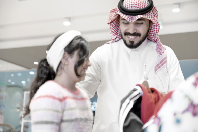 أب سعودي يختار الملابس مع إبنته , أب سعودي يتسوق مع إبنته في المركز التجاري , إبنه سعودية سعيدة  تتسوق مع والدها في المتجر 