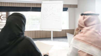 متدربان سعوديان  في دورة تدريبية ، رجل اعمال و سيدة اعمال في اجتماع لشرح استراتيجيات الشركة ، غرفة اجتماعات ، اجتماع عمل ، دورة تدريبية ، لوحة بيضاء لعرض الشرح