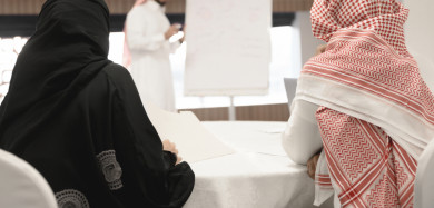 صورة مقربة لمتدربين سعوديين  في دورة تدريبية يقدمها مدرب ، رجل اعمال و سيدة اعمال في اجتماع لشرح استراتيجيات الشركة ، غرفة اجتماعات ، اجتماع عمل ، دورة تدريبية