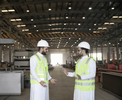 مهندسان صناعيان سعوديين شركاء في مصنع الحديد ، يتناقشان في جودة انتاج المصنع ، باللباس السعودي التقليدي ، مفهوم الهندسة و الصناعة