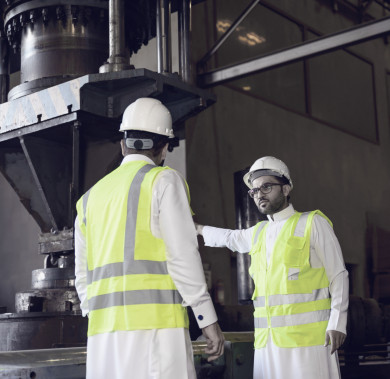 مهندسان صناعيان سعوديين داخل مصنع الحديد ،يشرفان على آلية عمل جهاز صناعة الحديد وكيفيه  تطويره ، ويحمل احدهم  مخطط بيده