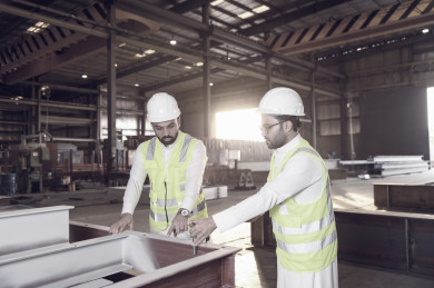 مهندسان صناعيان سعوديين شركاء في مصنع الحديد ، يتناقشان في جودة انتاج المصنع ، الاشراف على انتاجية الحديد و الألمنيوم في المصنع