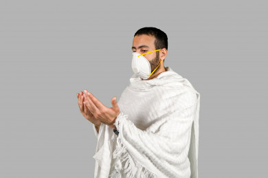 بورتريه لشاب سعودي خليجي بلباس الاحرام ويضع الكمامة ، اتباع اجراءات السلامة بوضع الكمامة بشكل صحيح ، تجنب انتشار العدوى ، خلفية بيضاء