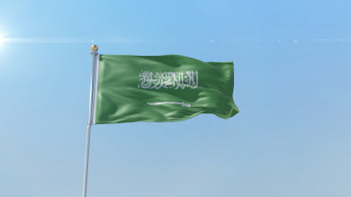 علم السعودية يرفرف في السماء ، في وضع النهار