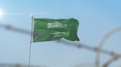 علم السعودية يرفرف في السماء ، في وضع النهار
