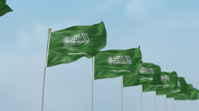 مجموعة  من أعلام السعودية في صفوف ترفرف في السماء 